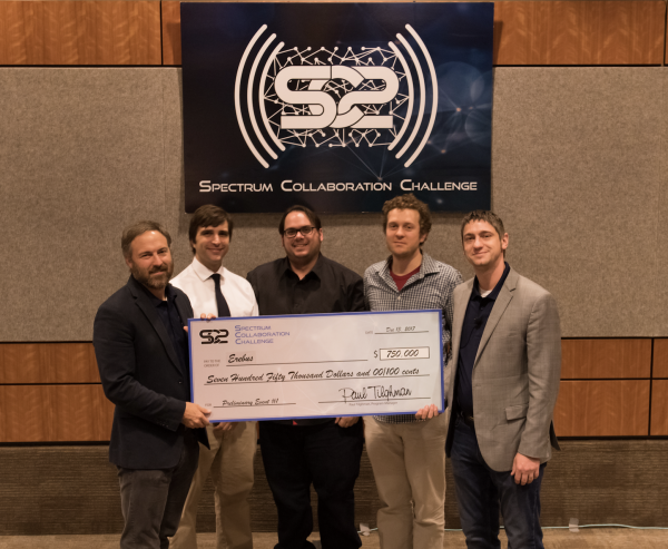 Spectrum Collaboration Challenge winners holding a check